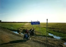 Ted's bike next to a sign outside Deadhorse, Alaska. There are no towns from Deadhorse to Coldfoot (244 miles)