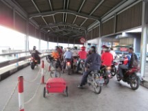 Motor scooter line to load ferry going from Butterworth to George Town, Malaysia