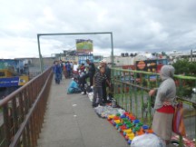 People selling stuff on bridge walking overpass in Guatemala City.