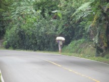 Man carrying his goods, it probably weights a lot.  People are always carrying big loads in Central America.