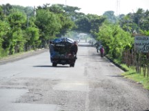 Fruit being sold from the back of a truck in El Salvador, people riding on the back of trucks is very common in Central America