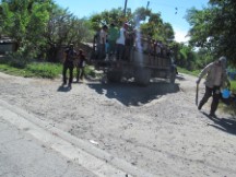 It’s common to see people loaded in the back of a truck as transportation.  It is also common to see people walking along the highway carrying machetes.