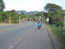 Lady in party dress getting a ride on a motorcycle in El Salvador