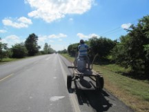 Man driving horse drawn carriage on highway in Nicaragua.