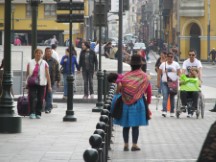 A lady carrying her child in historic center of Lima, Peru.