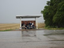 People wiating out a rain shower at a bus stop in Uruguay.