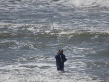 Man fishing in ocean near Punta del Este, Uruguay.