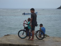 Cyclist on dock at Capurgana, Colombia.