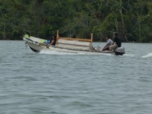 People moving a bed on the Rio Dulce between the town of Rio Dulce and Livingston, Guatemala.