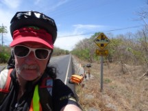 Ted with an animal crossing sign and his bike behind him.  This is on the Pan American highway between La Cruz and Liberia, Costa Rica.