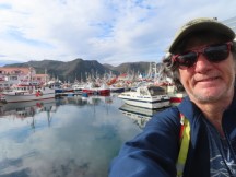 Ted in town of Honningsvåg, Norway with boats in the harbor.