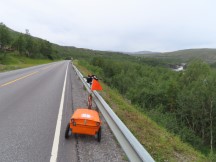 Ted’s bike on highway near above waterfall on highway slightly north of Alta, Norway.