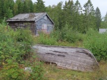 Historic log building and wood boat near Lövhällan trail on outskirts of Härnösand, Sweden. (Länsmuseets Sjöbodar)