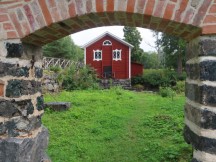 View of building from other building ruins window in Slottsparken at Axmarsbruk, Sweden.