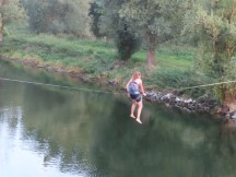 Lady doing acrobatics on a line next to the old stone bridge in Regensburg, Germany.