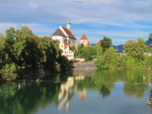 Franziskanerklosterkirche next to Lech River in Fssen, Germany.